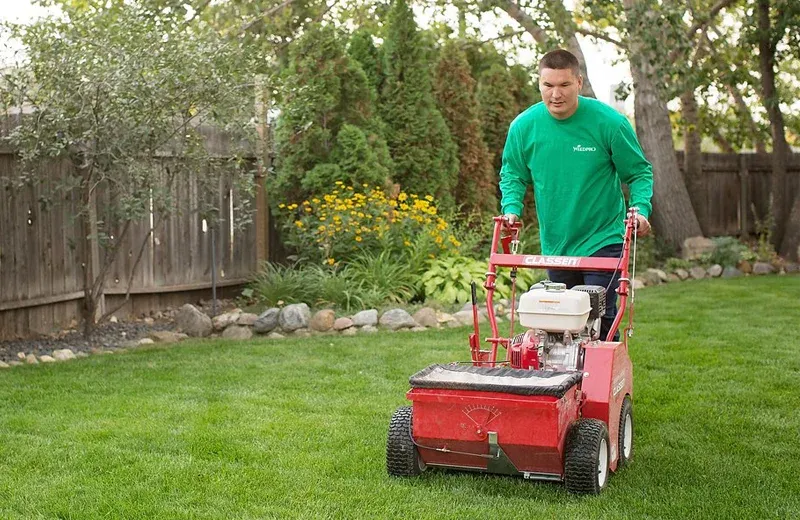lawn technician overseeding lawn