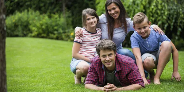 family laying in green healthy grass